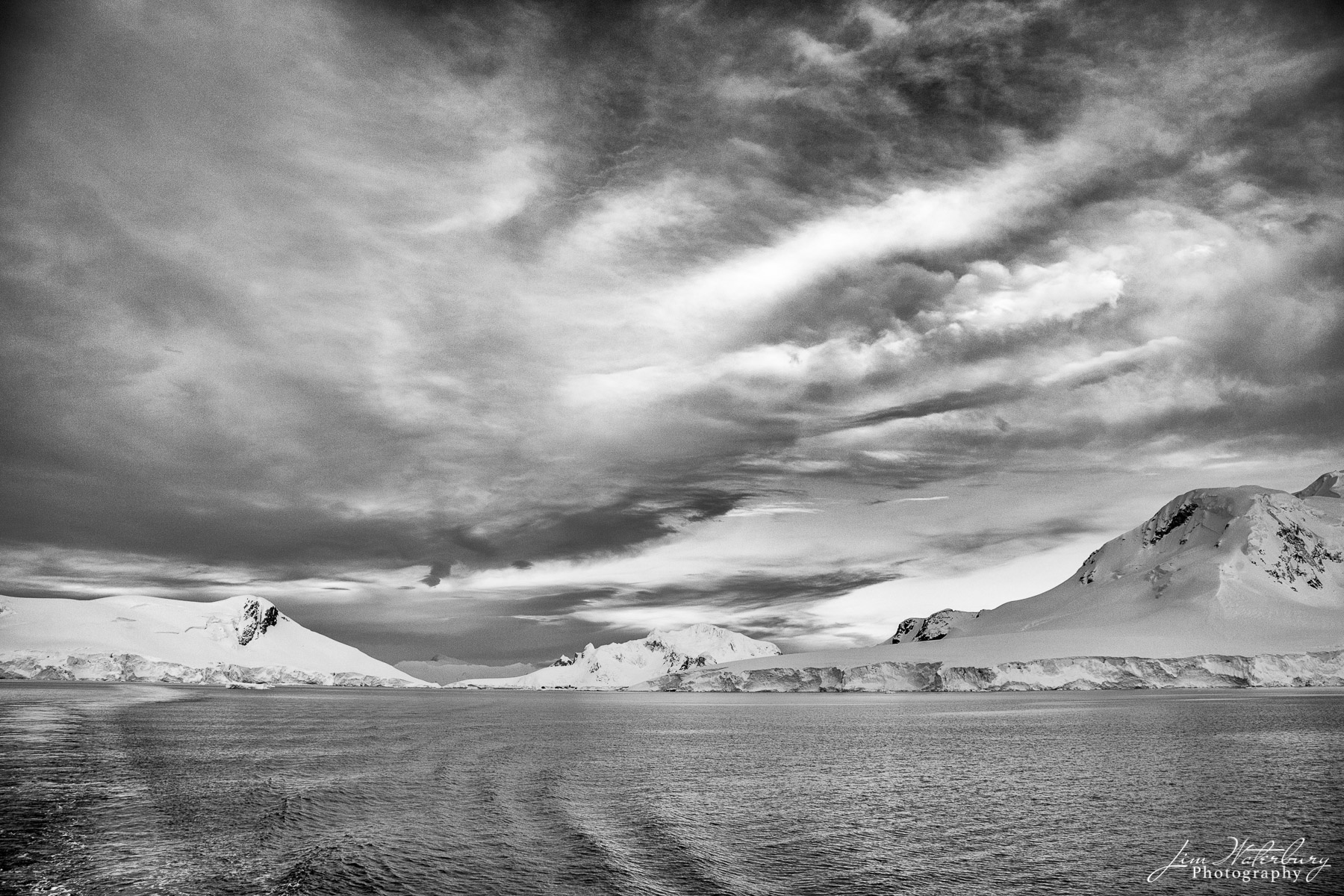 Andvord Skies Black & white image of sea, sky and snow-covered mountains of Android Bay, Antarctica.