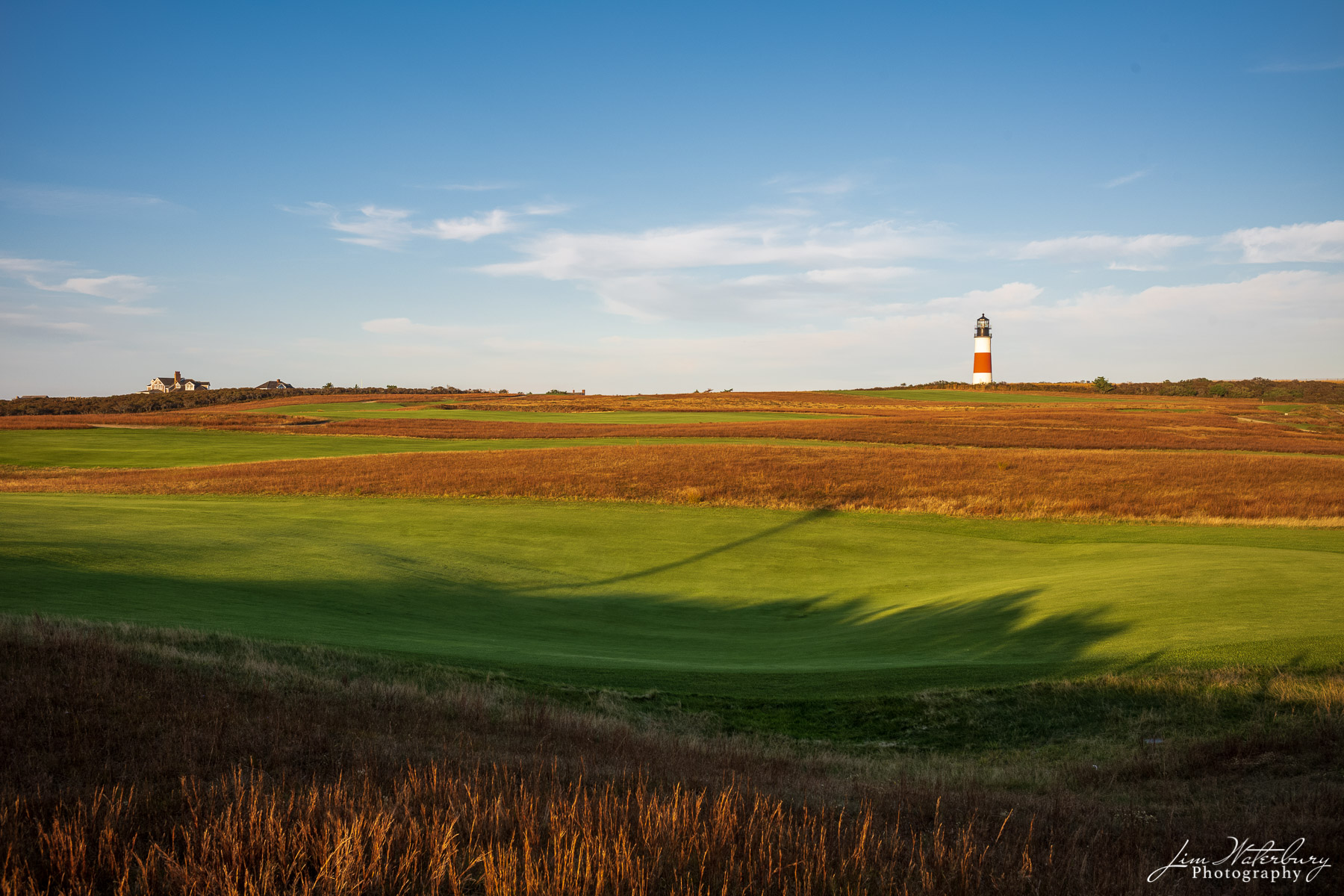 View of fairways on the Sankaty Head Golf Club on Nantucket, with the Sankaty Head Light in the distance.  The Sankaty golf course...