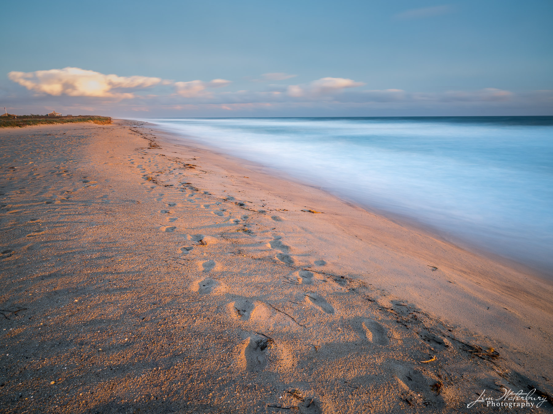 Footprints in the Sand Footprints in the sand lead down the beach, illuminated by the warm glow of the setting sun behind.