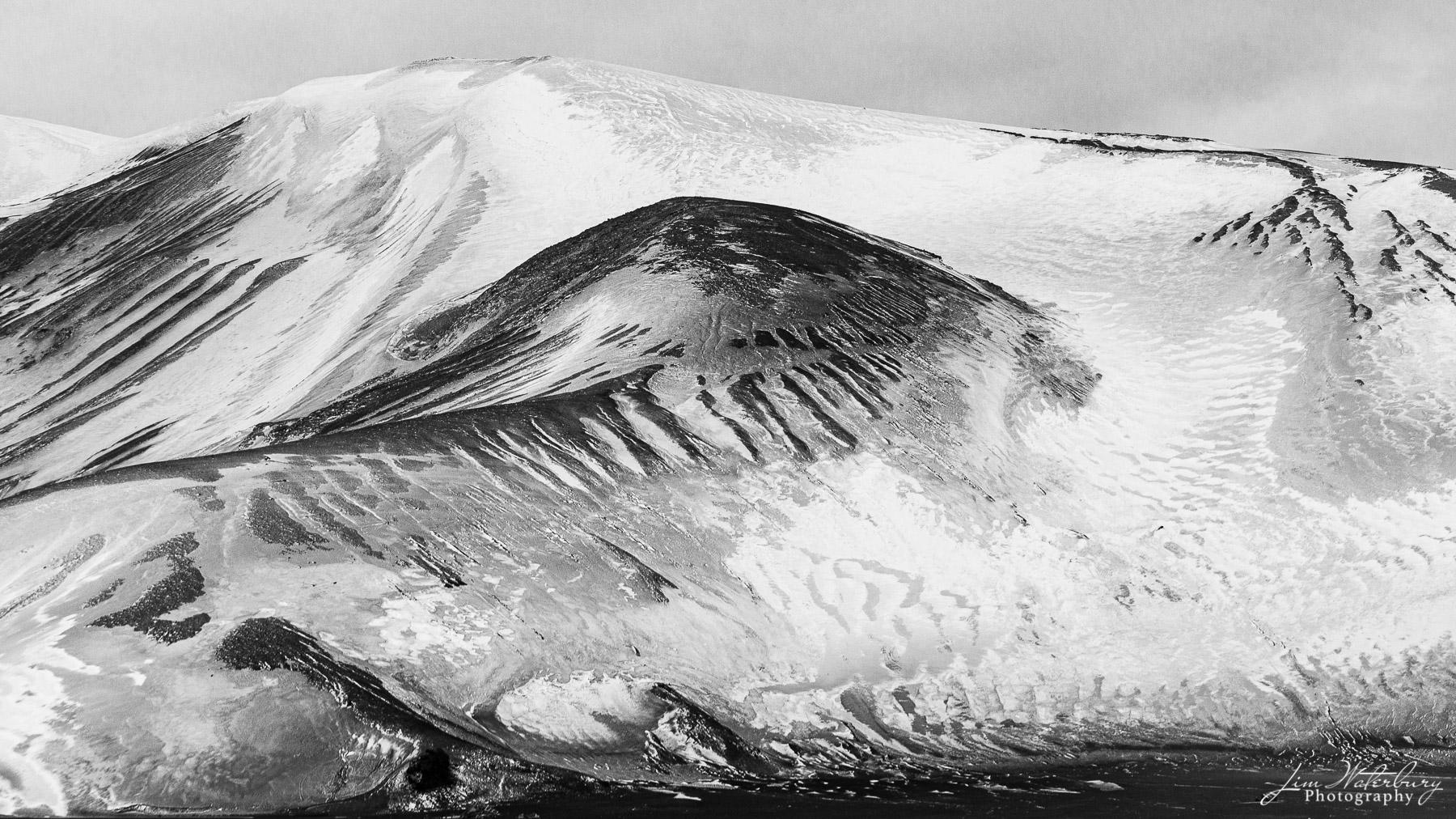 Slippery Slopes Patterns of snow and contrasting lava base at Deception island, Antarctica.