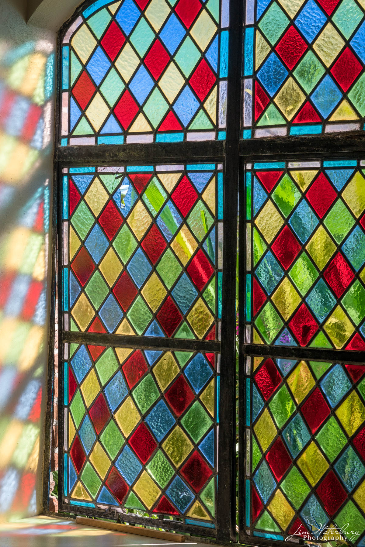 Church window, with stained glass, and reflection, in Antigua, BVI.