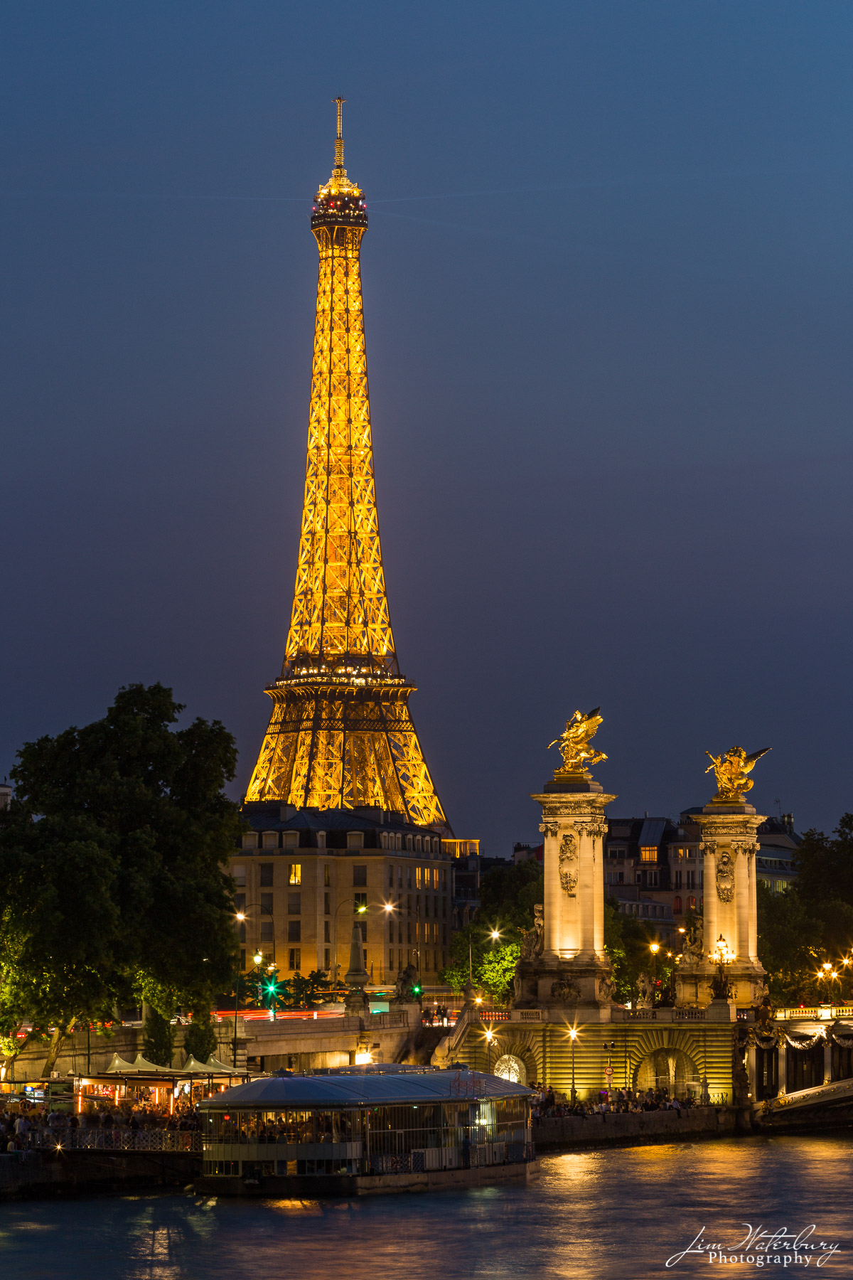 The Eiffel Tower, an iconic symbol of Paris and of France, stands over 1,000 feet tall, illuminated against the night sky.  The...