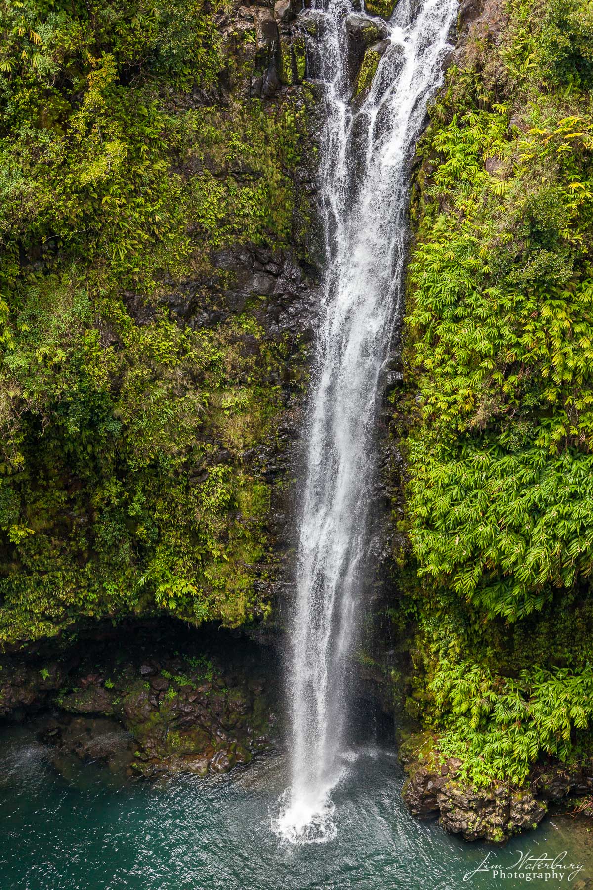 A waterfall drops hundreds of feet into the pool below, as photographed from a helicopter flying over the interior of the island...