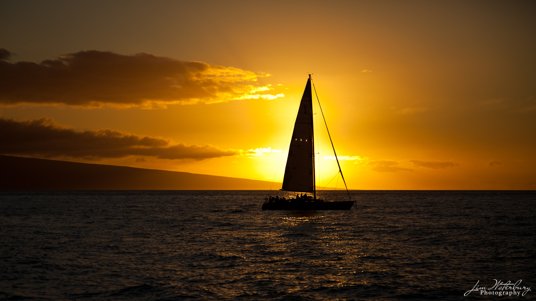 While sailing on a catamaran from Lanai to Maui, we passed this sailboat, just as it crossed in front of the setting sun.