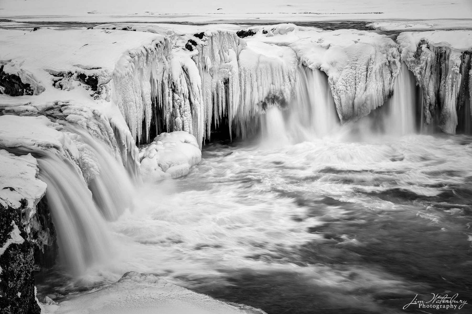 Frozen Black & white image of the partly frozen Godafoss waterfall ("Waterfall of the Gods") in Northern Iceland in winter.