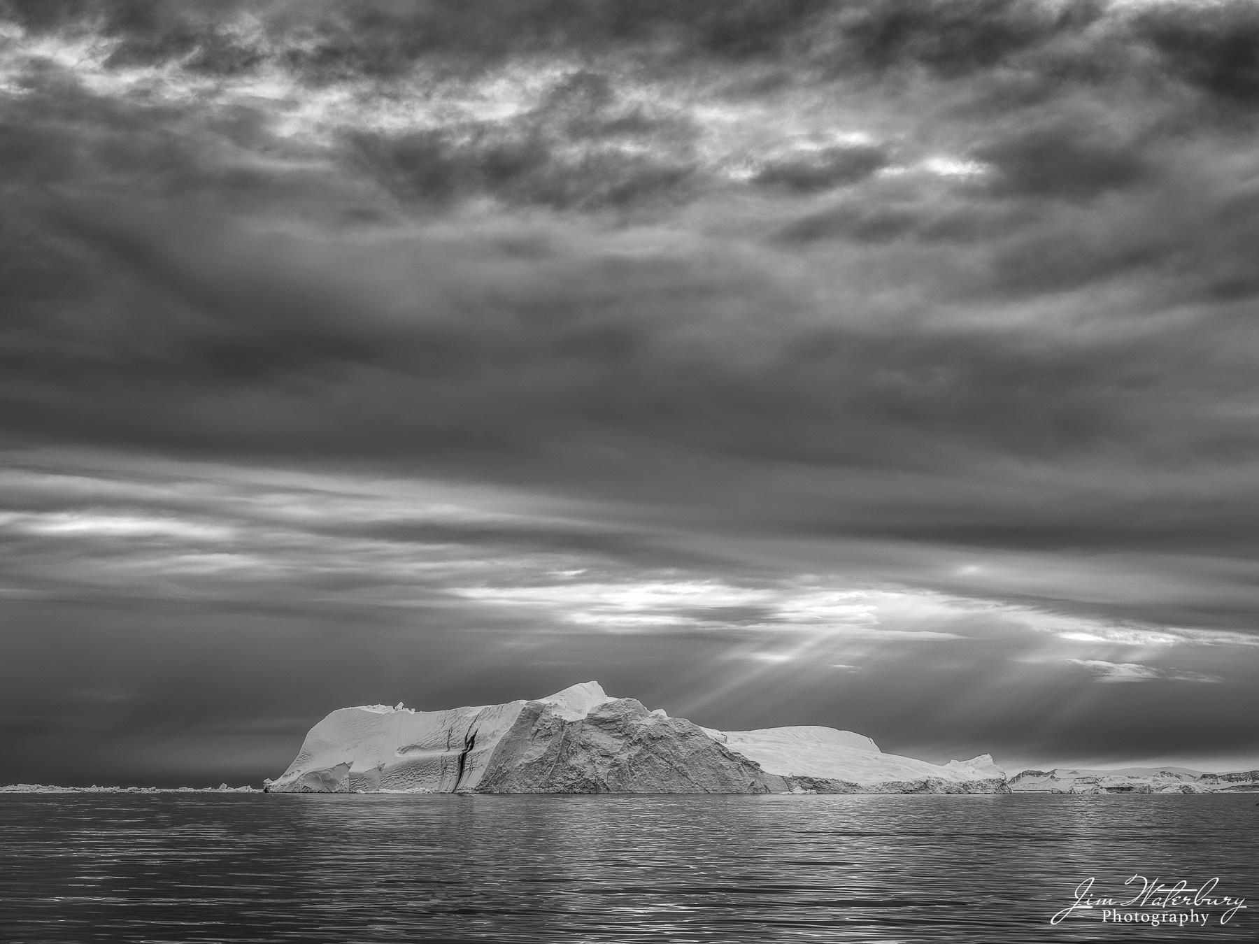 God Rays on Ice A large meandering iceberg catches the sun's rays from above in Disko Bay during a moody night (8:30 pm) in May.