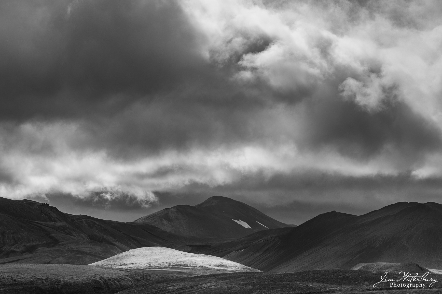 Light from Above Light peaks through stormy clouds to illuminate a hill in the Icelandic highlands.
