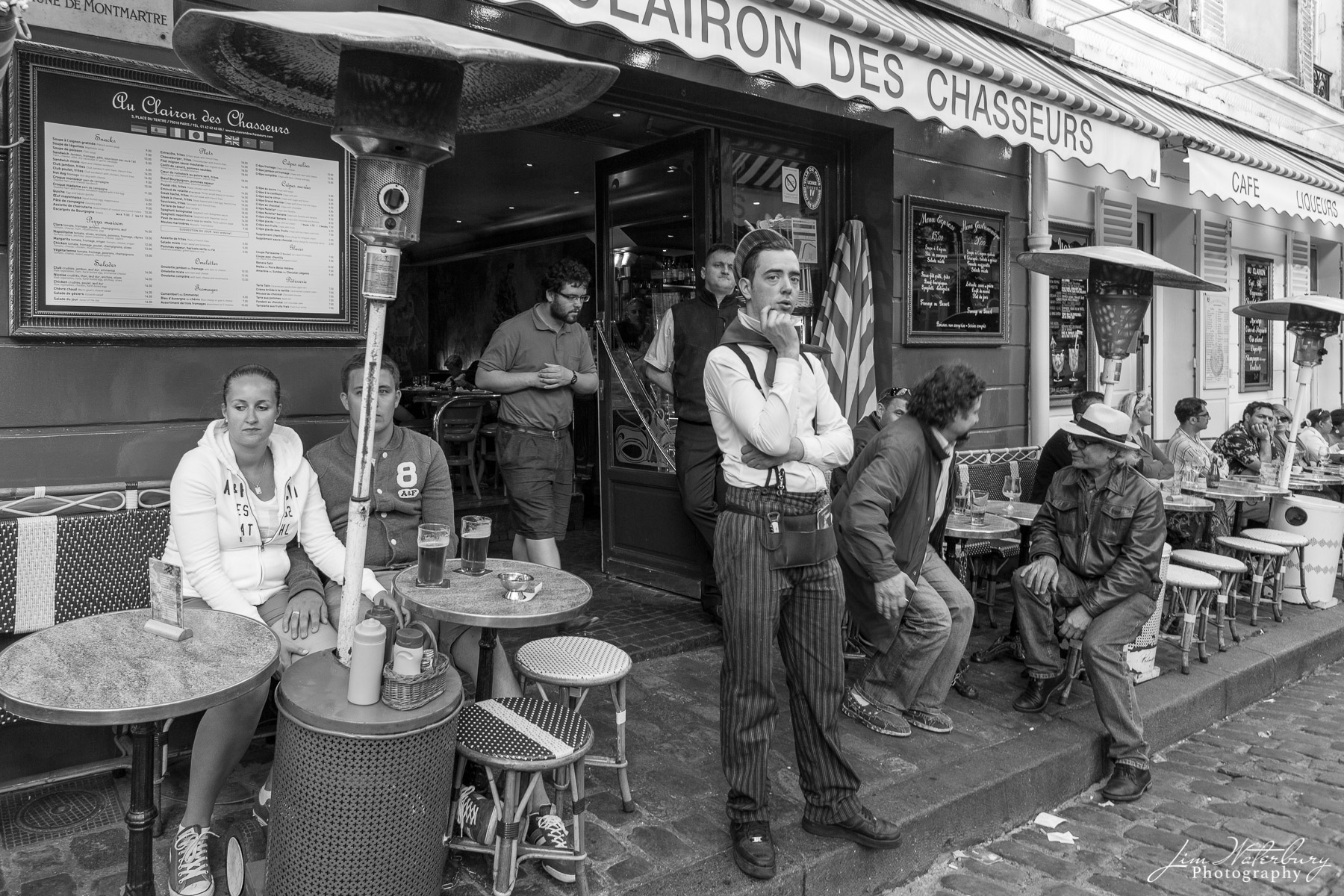 Le Regard Waiter keeps guard outside a local restaurant in Montmartre. Black & White.