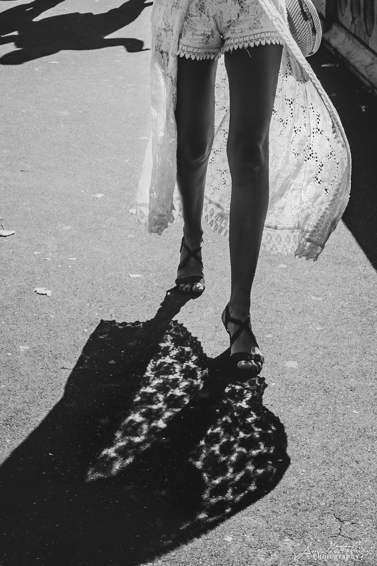 Woman in lace walks along the bridge leading to the Ile St. Louis, Paris. Black & white.