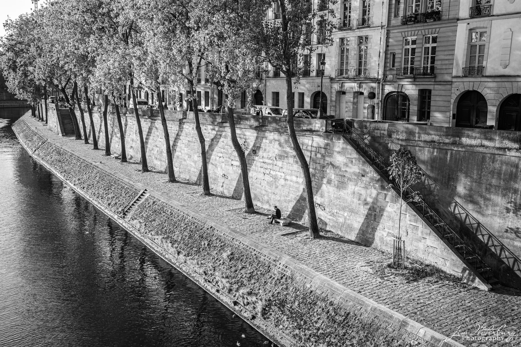 Meditation A lone gentlemen relaxes on a bench along the quai of the Seine on Ile St. Louis, Paris. Black & white.