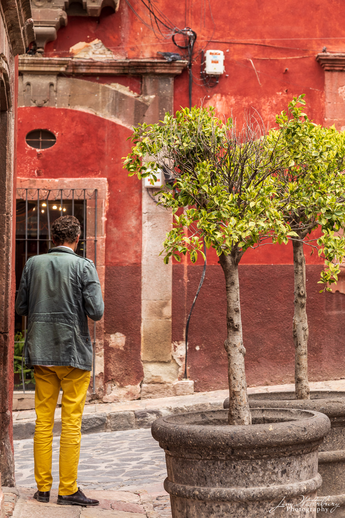 Yellow Pants Man in yellow pants checks his phone on a corner in central San Miguel de Allende, Mexico