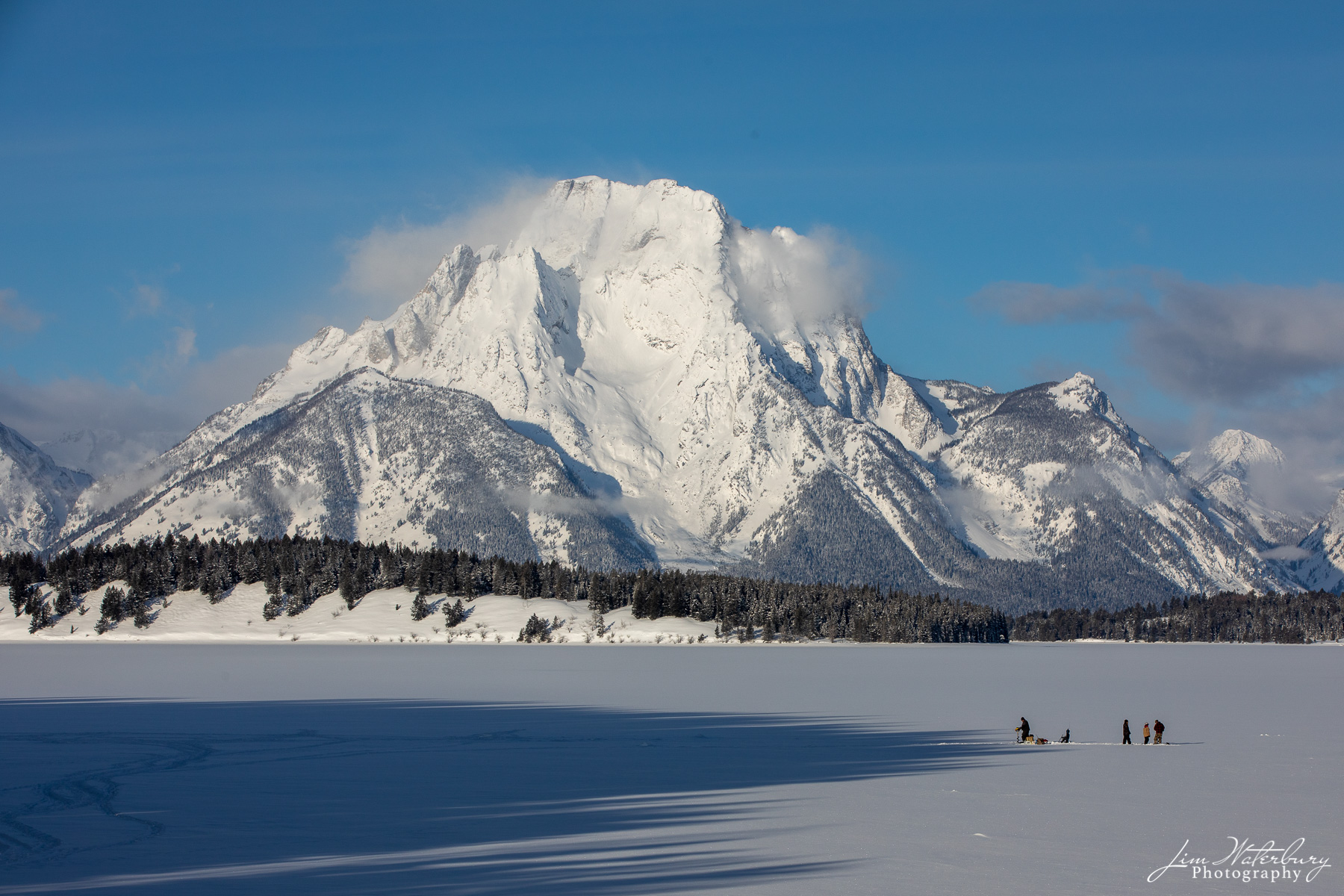 Ice Fishing With Mt Moran in the background, hearty locals prepare to go ice fishing on Jackson Lake, Grand Teton National Park.