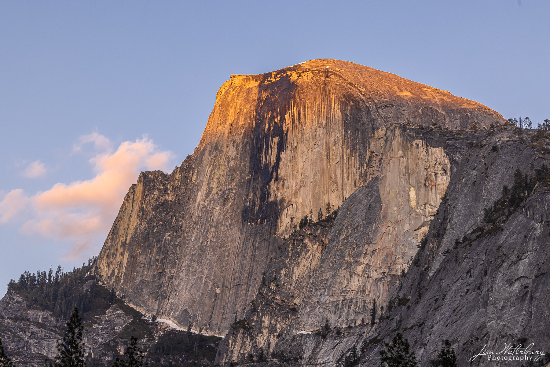 Half Dome, with the last warm light of the day hitting the peaks and lighting up nearby clouds.