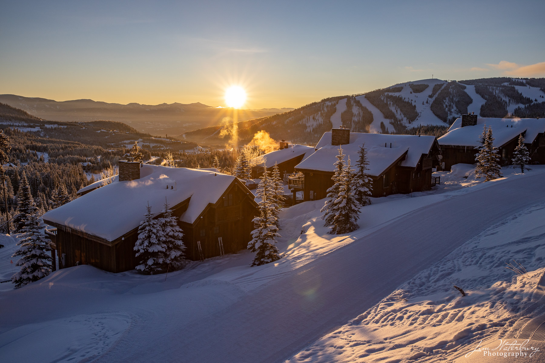The sun rises over ski cottages set in new-fallen snow at Moonlight Basin,  Big Sky Ski Resort, Montana.