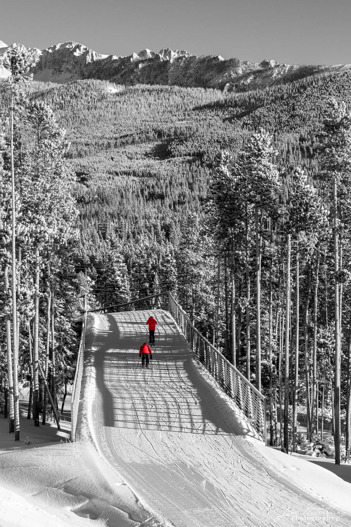 Red Jackets Two skiers cross a bridge to link up with the main runs at Big Sky ski resort, Big Sky, Montana.